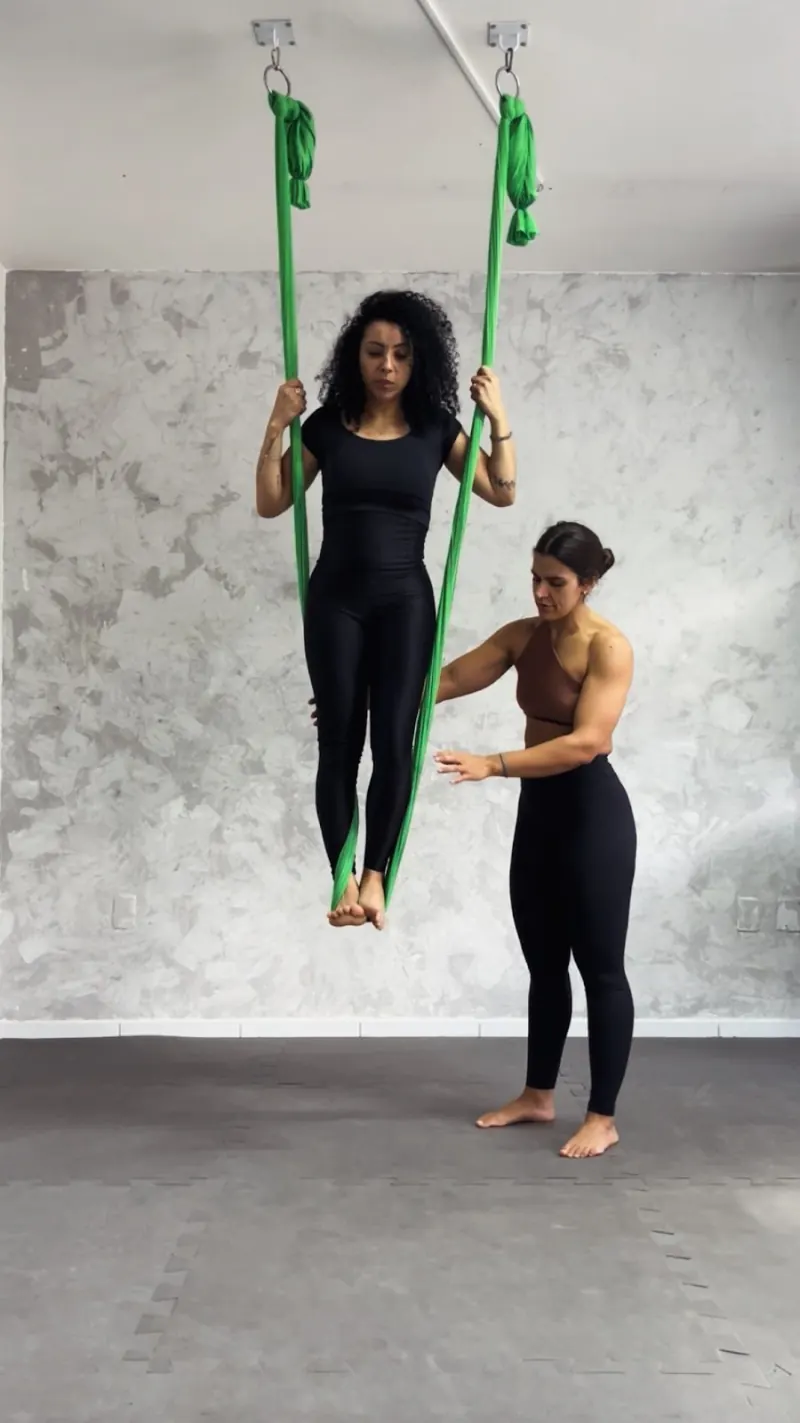 Erika orientando uma aluna sentada no tecido