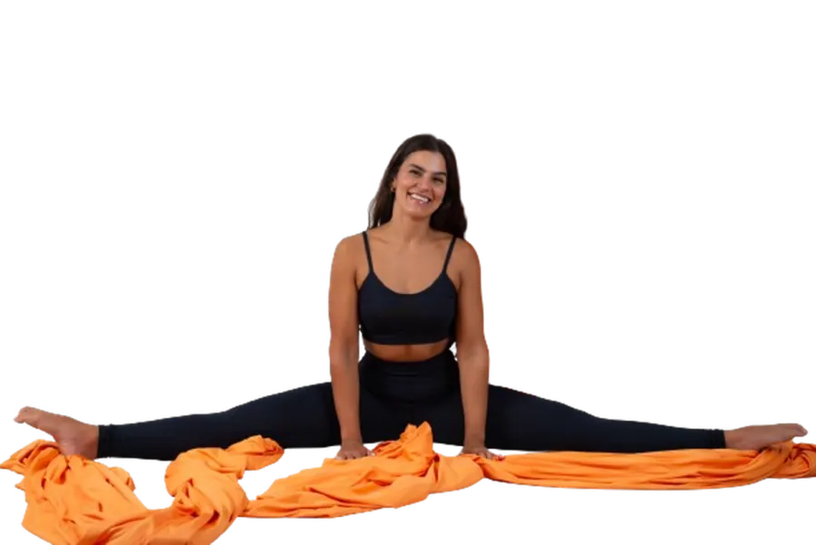 Erika Abel sentada em espacate sobre o tecido, sorrindo